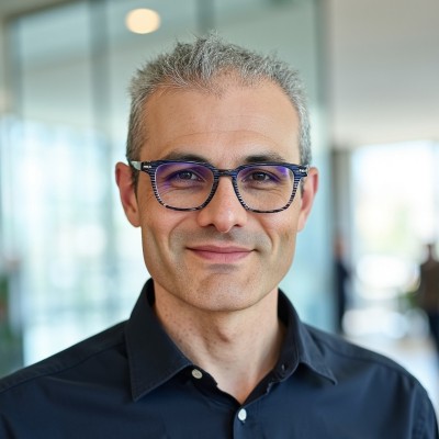 Hombre mediana edad. Lleva gafas. Pelo corto canoso.